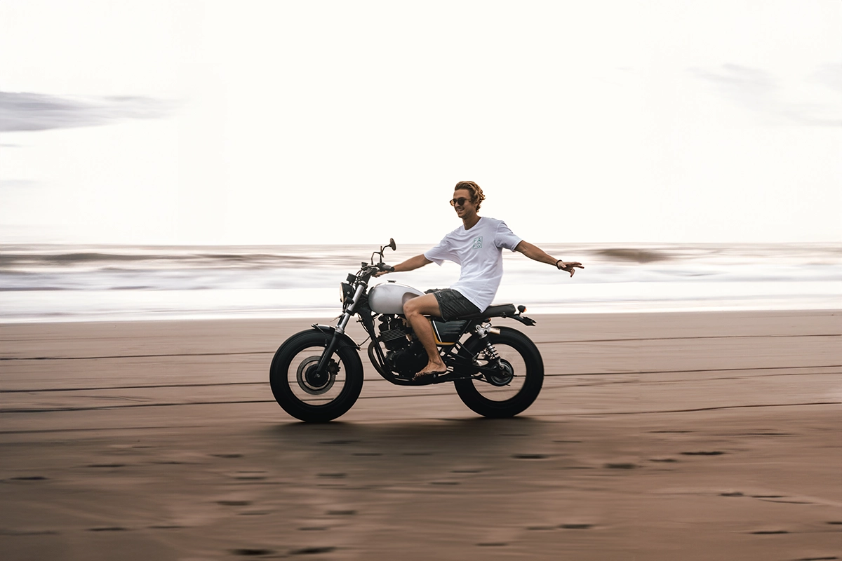 Hombre conduciendo moto en la playa